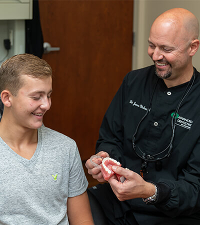 Dentist and patient looking at smile model