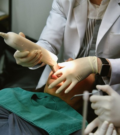 a dentist taking digital scans of a patient’s mouth