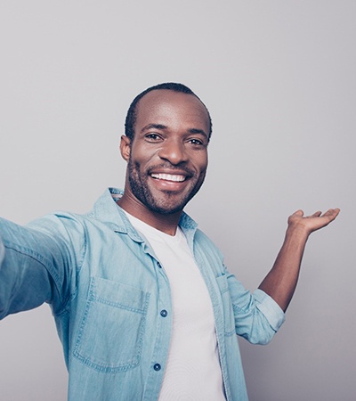 man smiling and taking a selfie after working with a cosmetic dentist in Dayton