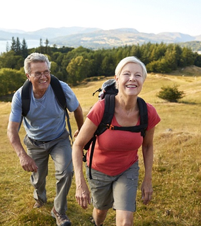 a couple hiking up a hill and smiling