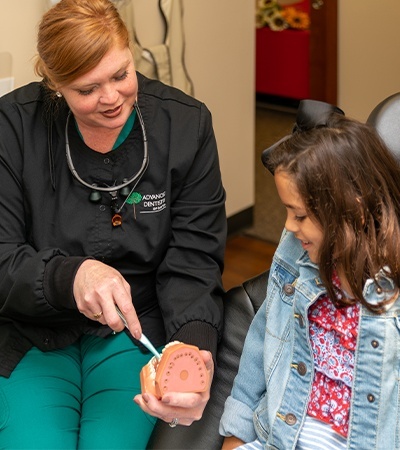 Dentist and young patient practing at home oral hygiene to prevent dental emergencies