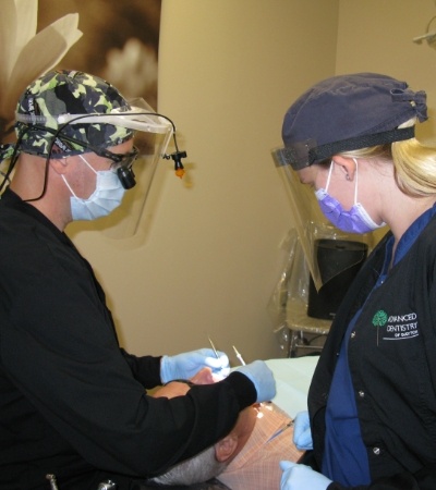 Dentist and team member providing dental implant supported replacement tooth