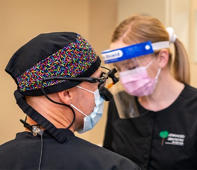 Dentist and team member providing dental implant supported replacement tooth