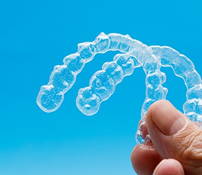 person holding two clear aligners