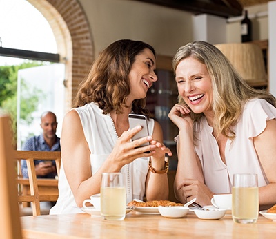 Two friends smiling in restaurant