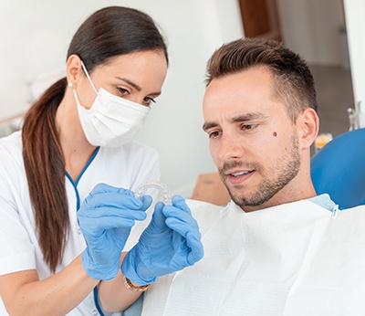Dental assistant showing patient clear aligner