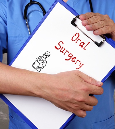 Doctor holding clipboard that says “oral surgery”