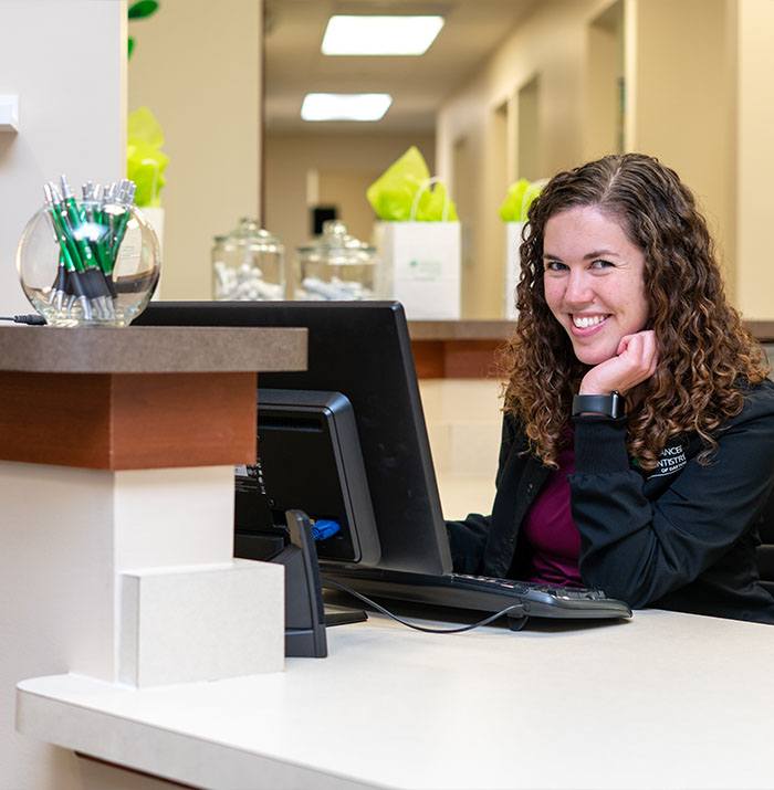 Dental team member smiling at patient visiting dental office for restorative dentistry