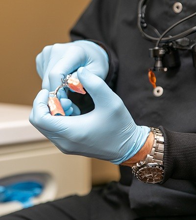 Hand holding partial denture