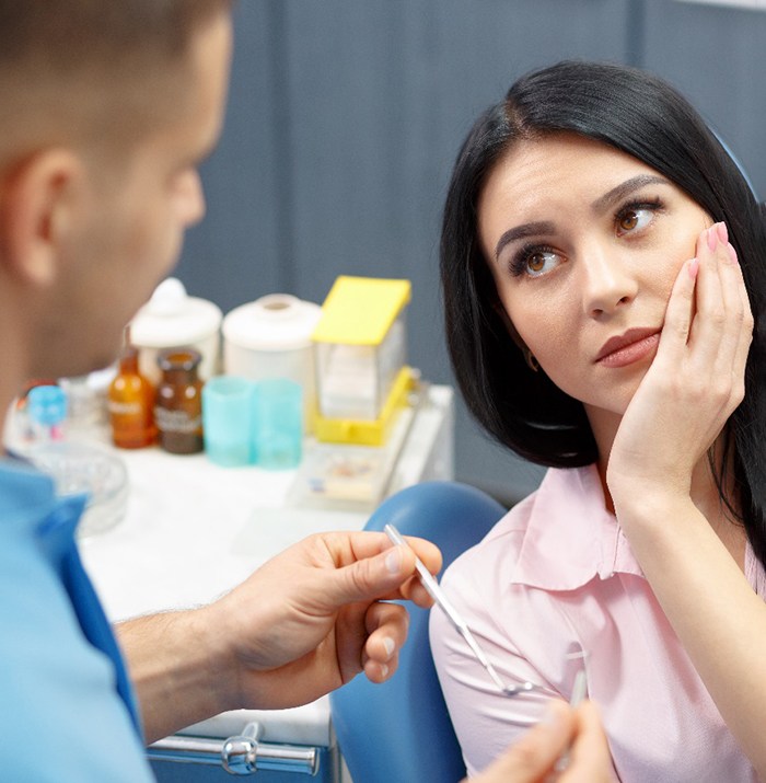 A woman about to receive a root canal who’s talking to her dentist