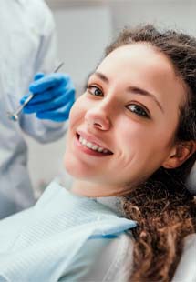 Dental team member and patient smiling in dental office