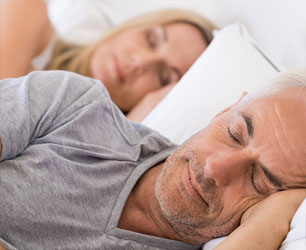 Man and woman sleeping soundly thanks to sleep apnea therapy