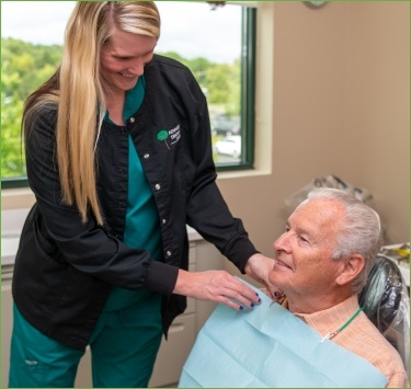 Older man in dental chair for preventive dentistry exam