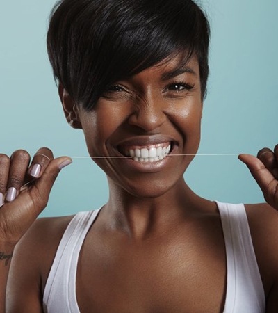 Smiling woman flossing after professional Zoom! teeth whitening in Sugarcreek Township