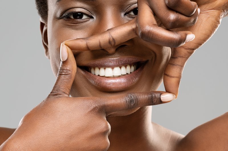 young woman framing smile with her fingers