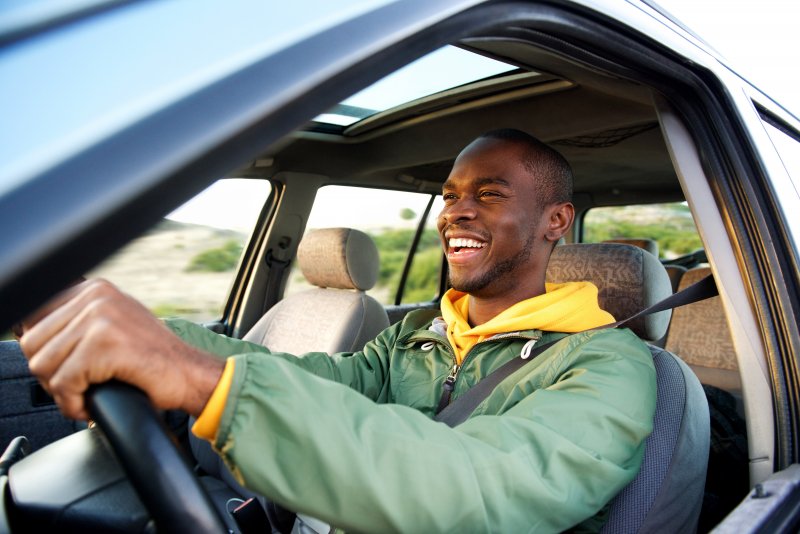 Man smiles while driving